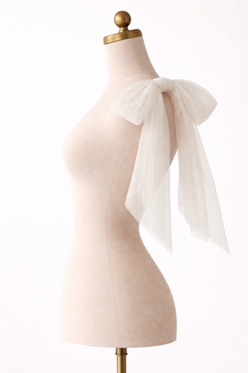 Mannequin wearing a white tulle bow on a plain background