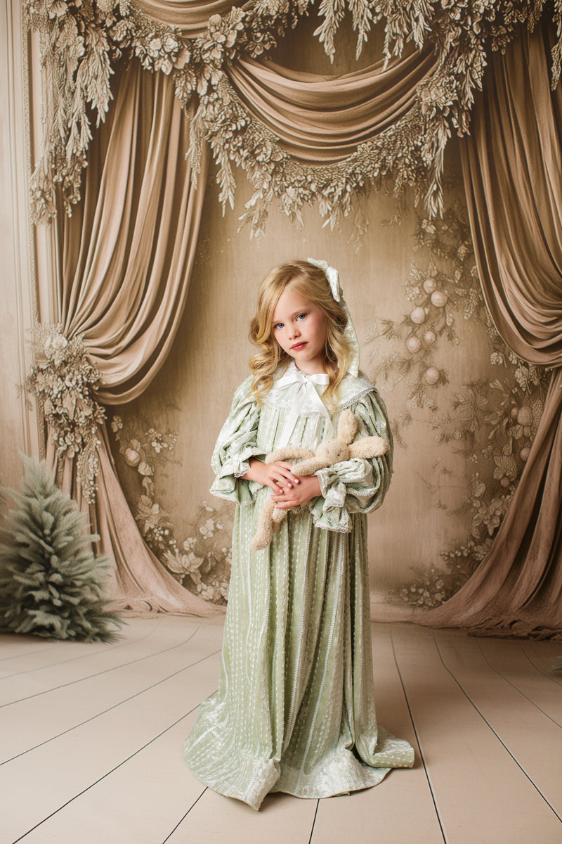 Child in Eleanor’s Dream vintage sage gown showing gathered sleeves and romantic silhouette in outdoor photography setting.

