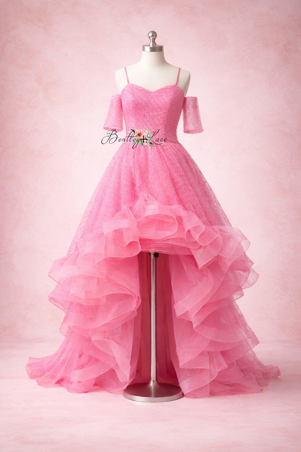 Pink evening gown on a mannequin against a pink background