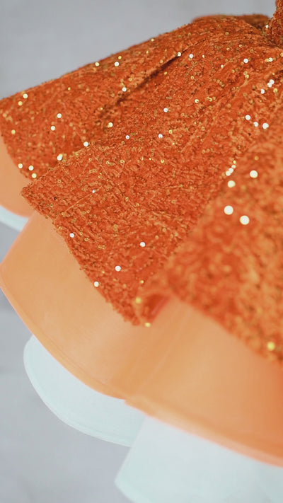 Close-up of orange sequin bodice with layered organza and tulle skirt on Sparkling Starlet Couture Dress.