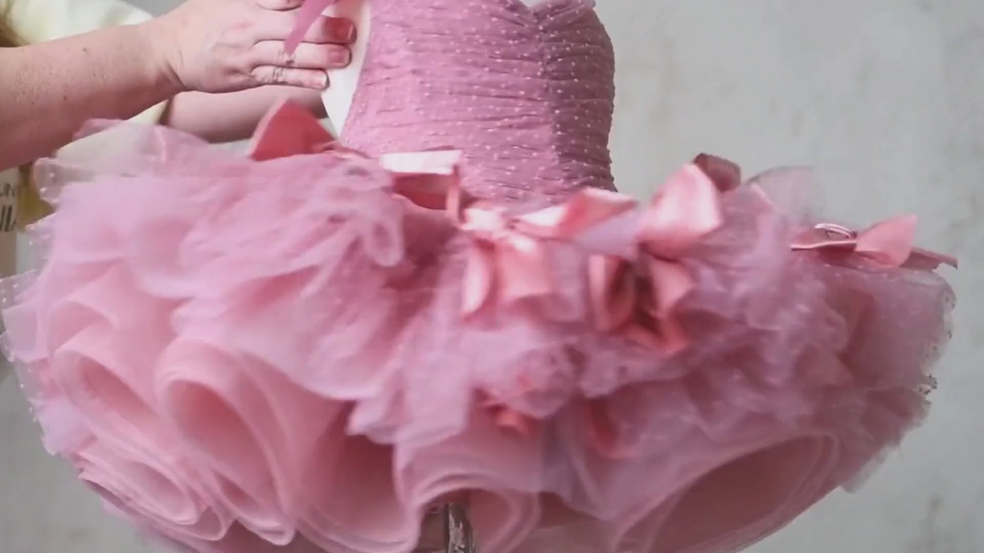 Close-up of a vintage-inspired dusty rose dress featuring ruched bodice and layered tulle skirt.
