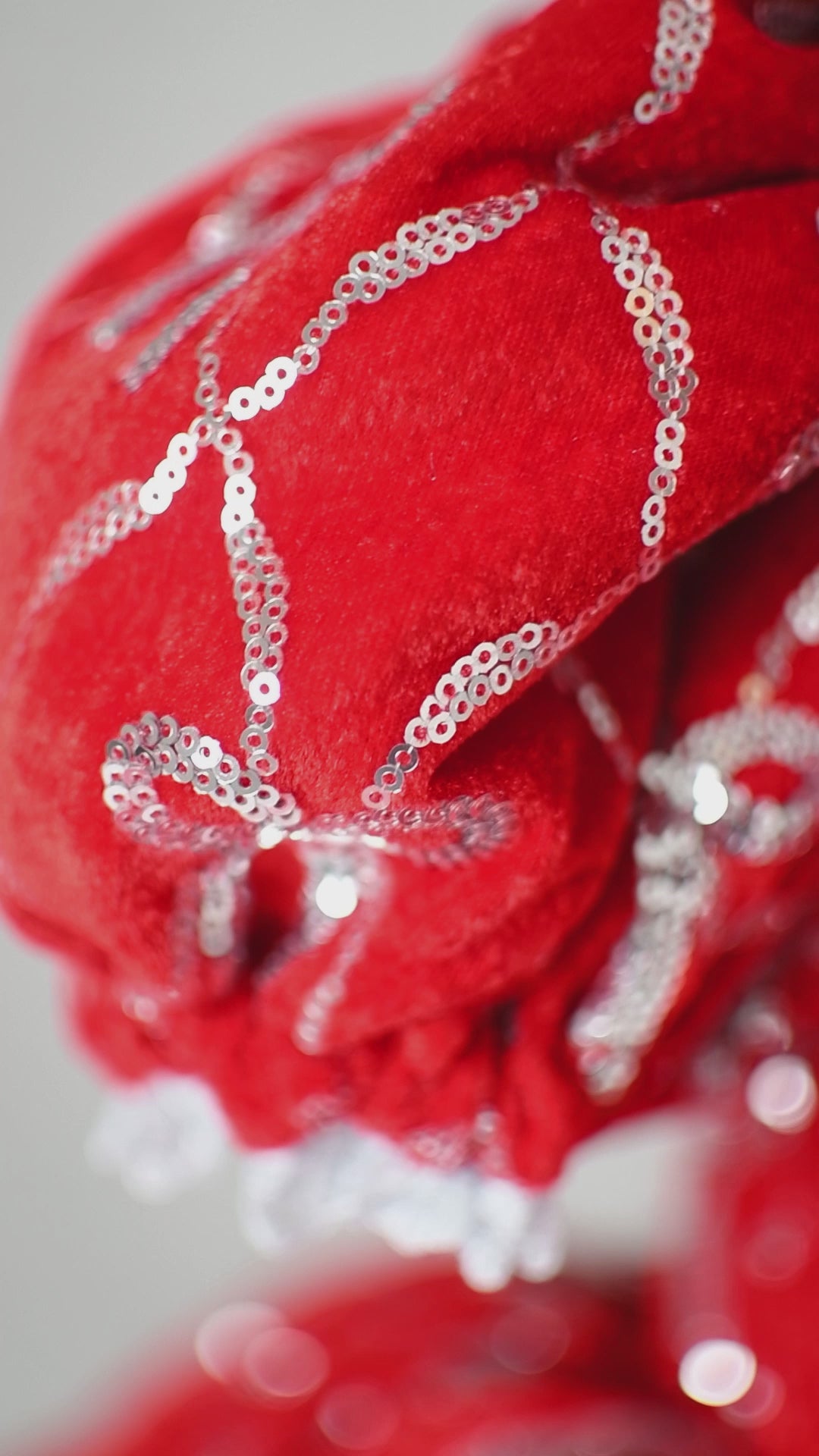 Full skirt detail showing silver bow embroidery on red velvet fabric.


