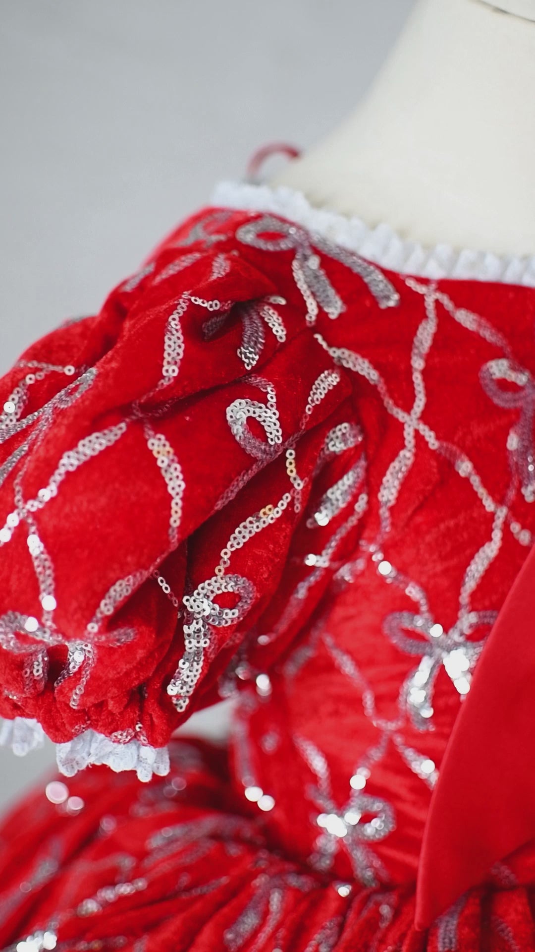 Detachable hooded cape with faux fur trim and red satin bow shown with dress.

