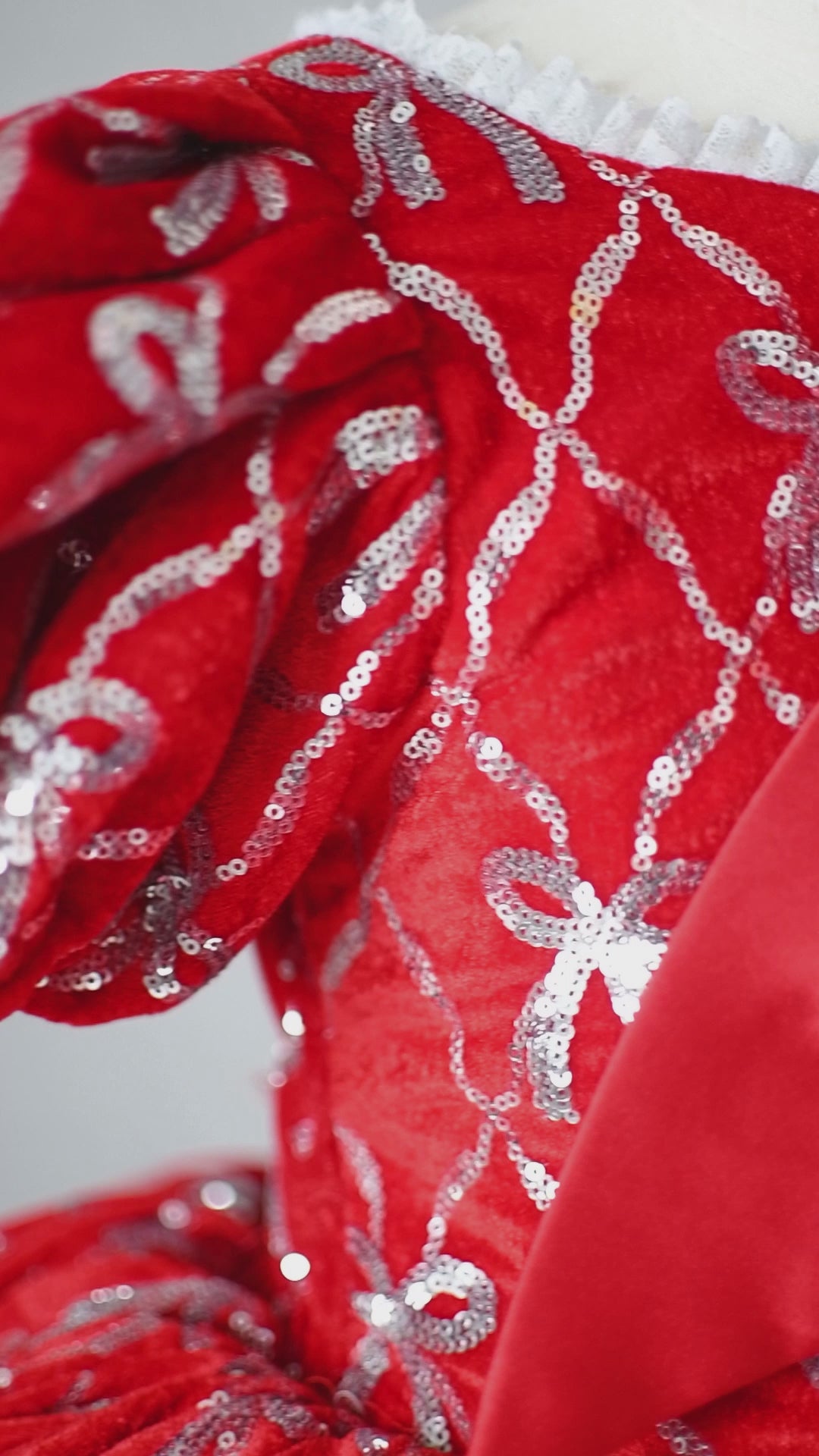 Top-down view of the dress highlighting intricate silver bow embroidery.

