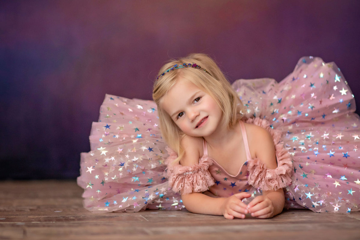 Young girl posing in twirl-ready dress with magical star print

