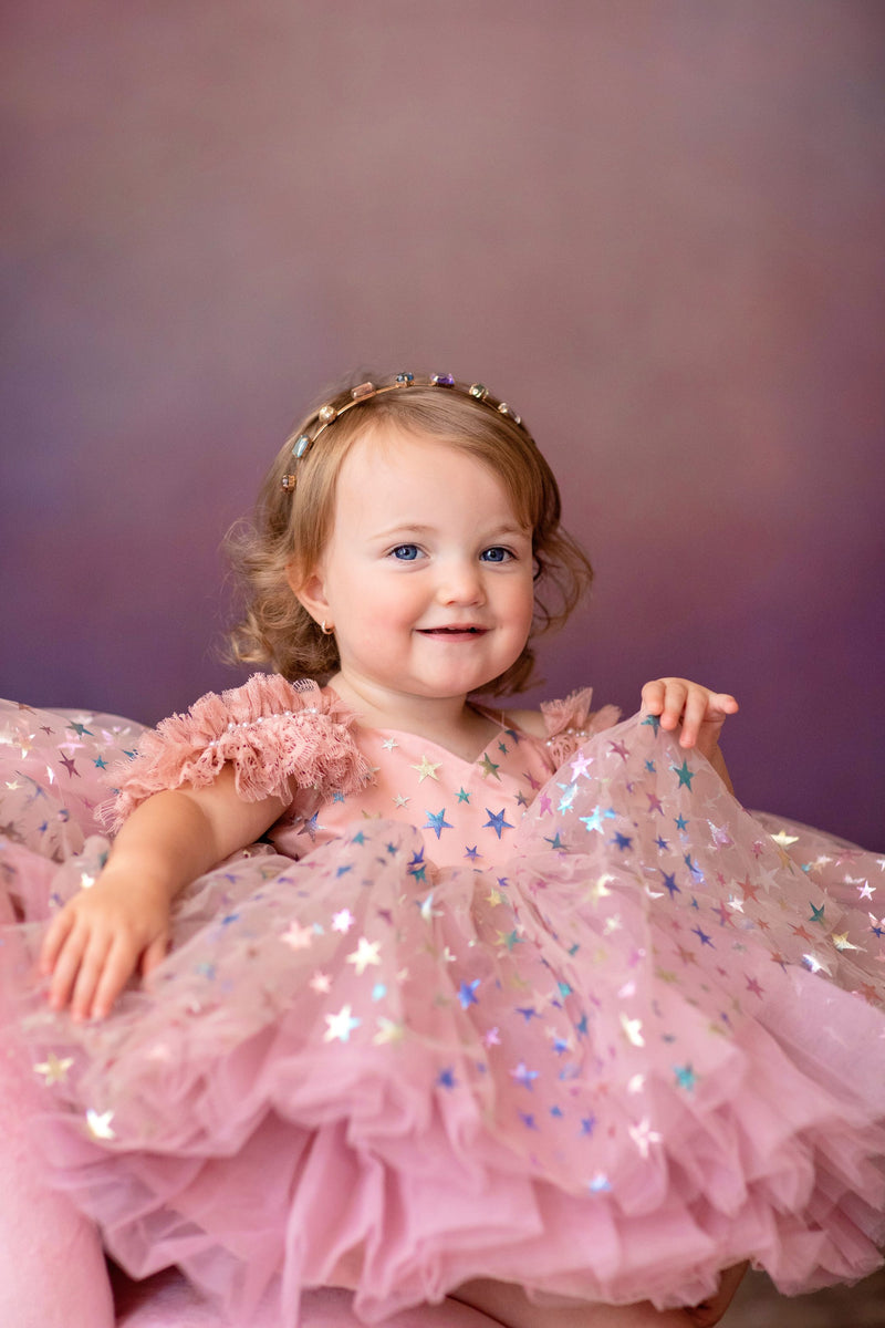 Child wearing sparkly vintage-style dress in outdoor birthday shoot

