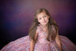 Girl twirling in Star Confetti gown with peachy pink tulle layers

