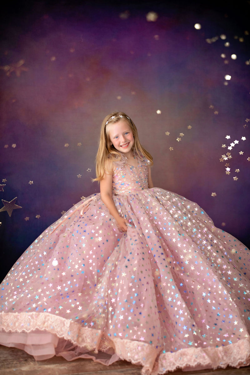 Girl twirling in Star Confetti gown with peachy pink tulle layers

