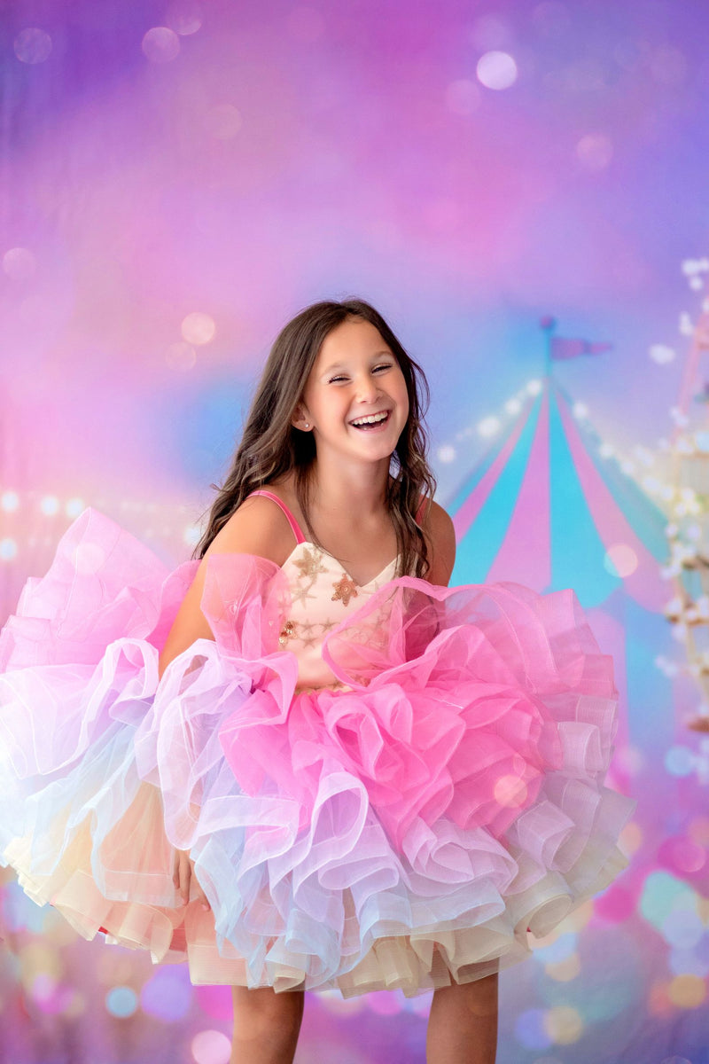 Little girl wearing the Petal Golden Starlight gown with embroidered star mesh

