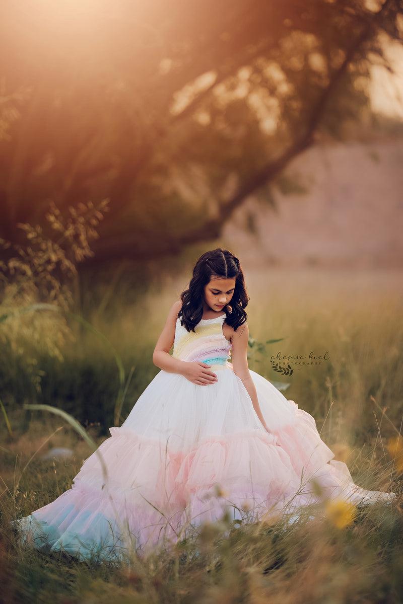 A multicolored striped dress with long sleeves and a tie waist, combining comfort with a bold rainbow aesthetic.

