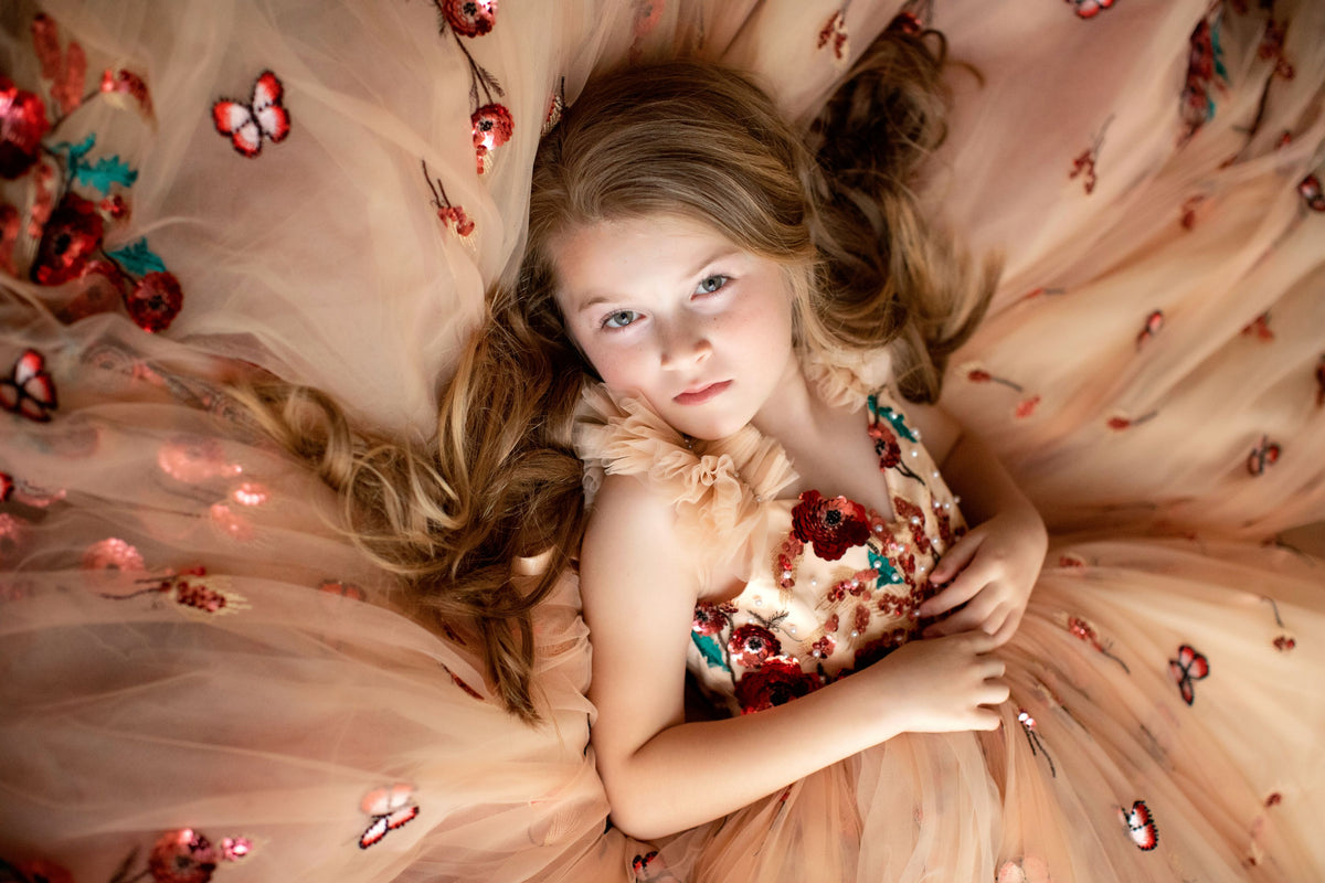 Young girl wearing a floral sequin gown for a flower girl photoshoot

