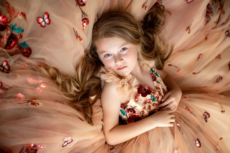 Young girl wearing a floral sequin gown for a flower girl photoshoot


