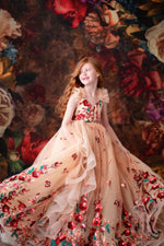 A child twirling in the gown in a field of wildflowers at golden hour — soft sunlight, dreamy blur.

