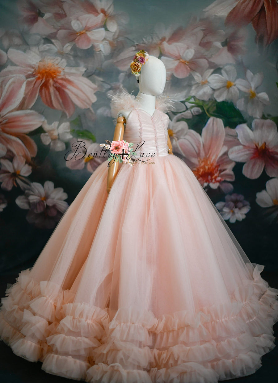 A floor-length pink floral dress with tulle and bead detailing, designed for special occasions.